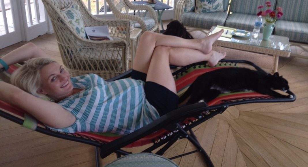 A pregnant mom on bed rest lays on a reclined lounge chair.