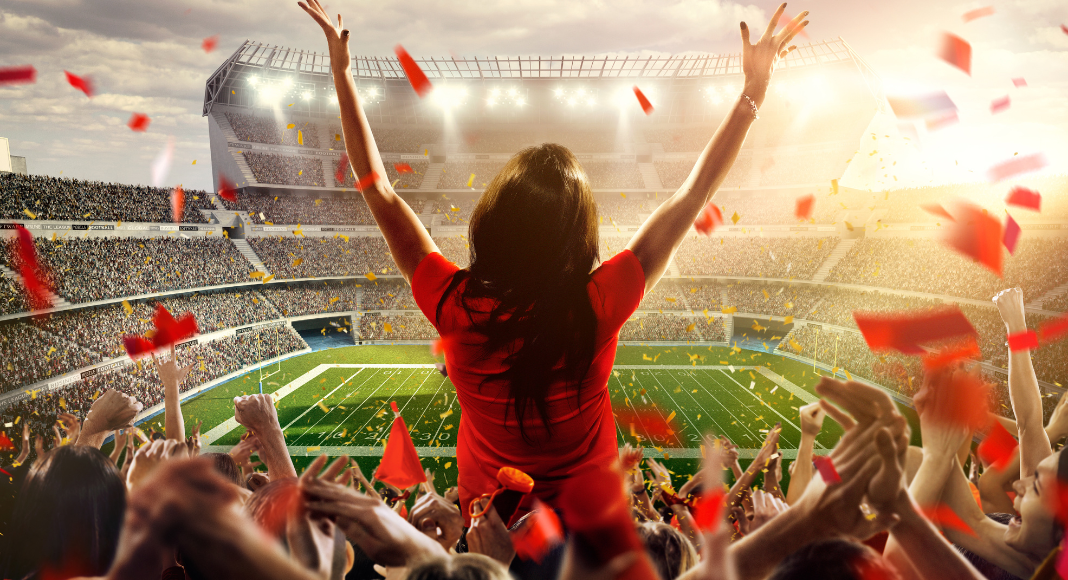 a woman cheering in a football stadium