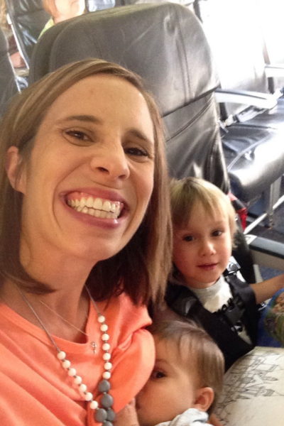 A mom flying solo with two young children, sitting on an airplane together.