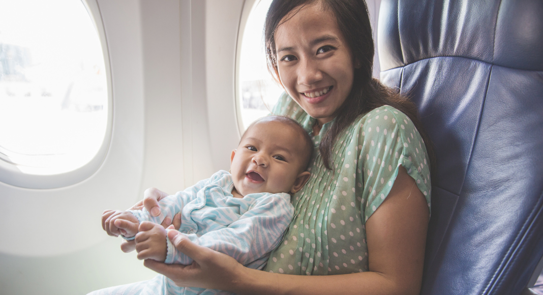 A mom flying solo with a baby in her lap.