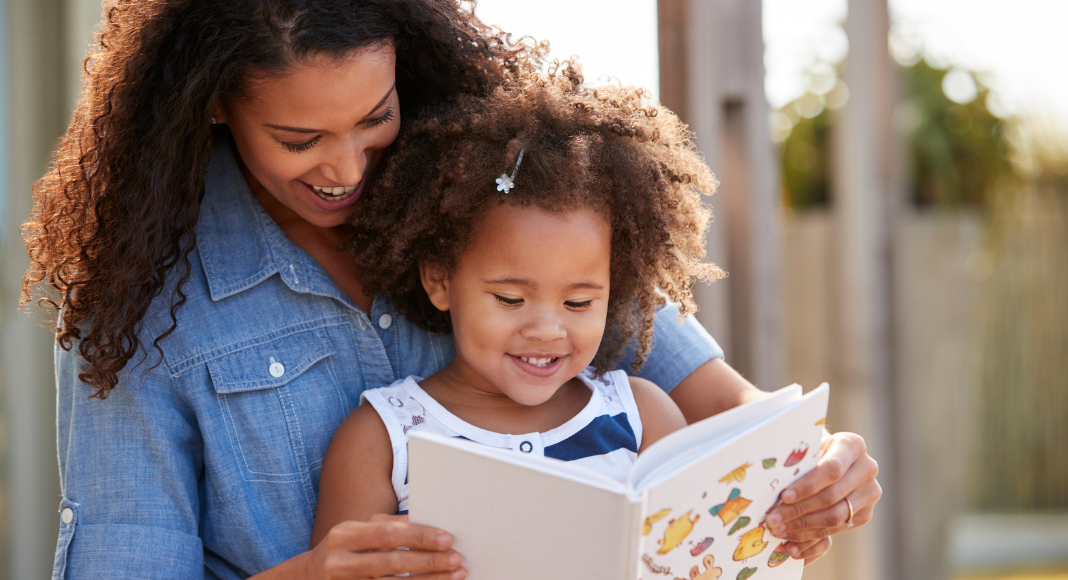 kid recommended books: a mom reads a book to her young daughter.