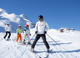 ski resorts: a family of four ski down a snowy mountain