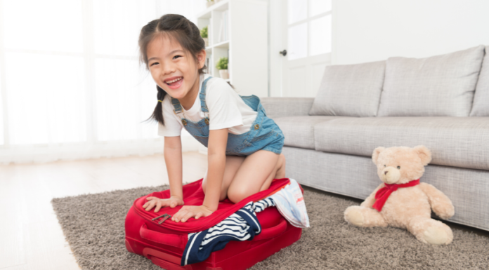 Little girl packs her suitcase as a houseguest.