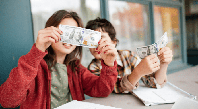 child's money personality; two children holding up paper money.