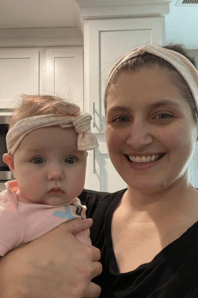A mom holding her baby girl, both wearing pink polka dot headbands. The mom is smiling after starting her antidepressant medication.