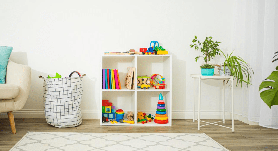 a playroom with cube organizer shelf and fabric bin holding toys.