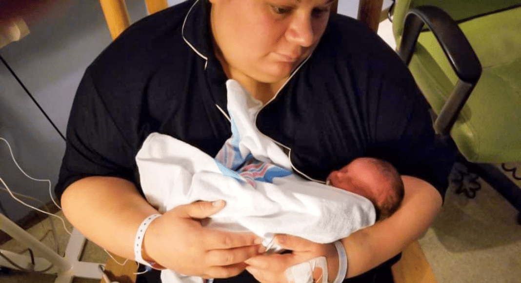 a mother holds her baby in the hospital