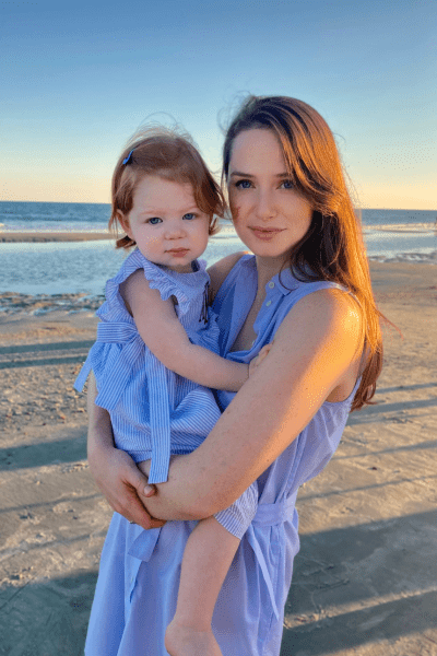 Raising a Child Who Is Just Like You: a mom holds her toddler daughter, posing at the beach