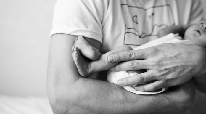 Father's Day Poem: a father holds a newborn baby in his arms.
