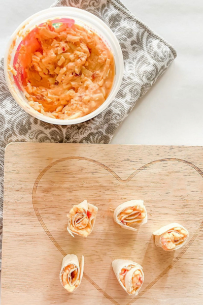 Pimento Cheese Rollups on a heart shaped serving board