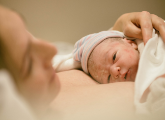 The Birthing Experience: a mom holds her newborn baby on her chest.