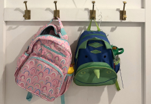 Two small backpacks hang on hooks for the school morning.