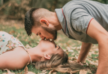 Bring sexy back: A couple kisses on the grass.