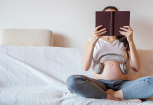 books for breastfeeding moms: a pregnant woman reads a book in bed.