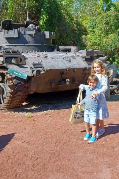 Two kids posed in front of a military tank at Patriots Point.