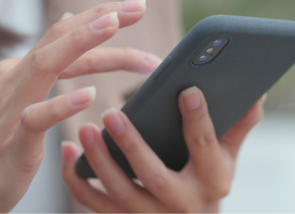 A close-up of a woman's hands holding a cell phone.