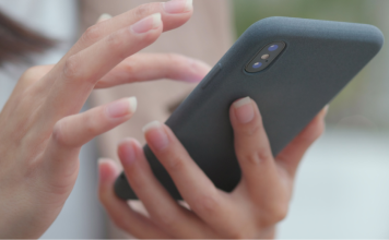 A close-up of a woman's hands holding a cell phone.