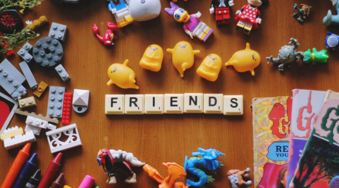 Friends spelled out in game piece tiles surrounded by small toys