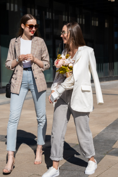 two women in full fall trends with their business outfits of relaxed-fitting trousers and blazers 