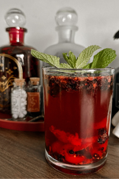 Halloween cocktails: Red colored mocktail drink with green sprig on top