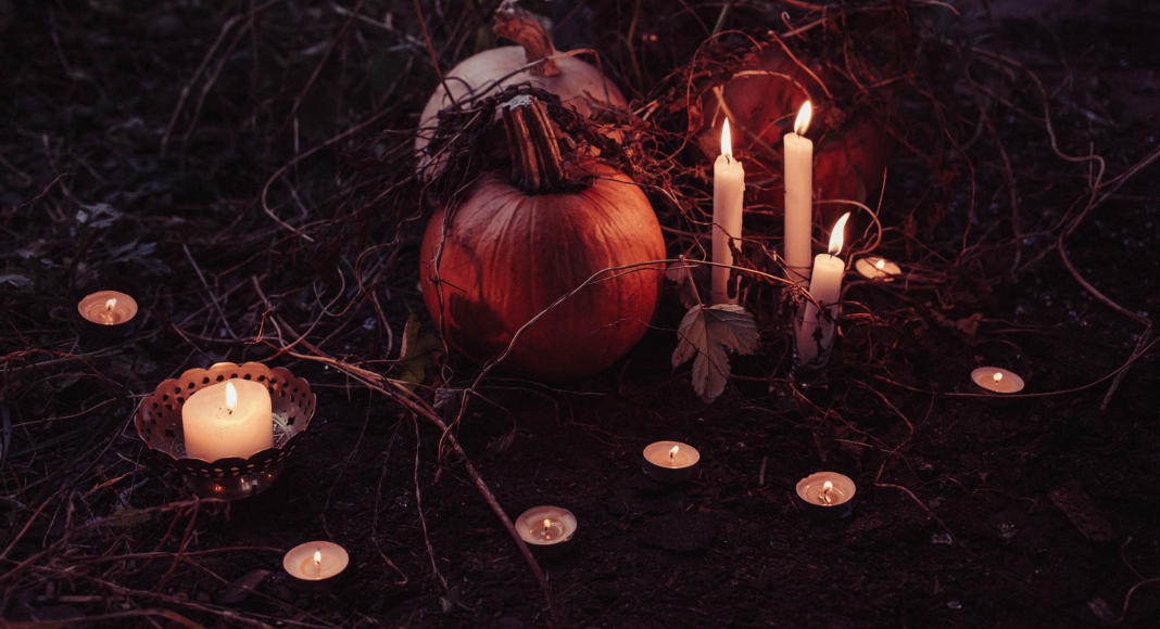 pumpkins surrounded by lit candles