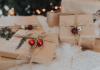 Small business gifts: presents wrapped in brown paper with string and small bells lay under a tree