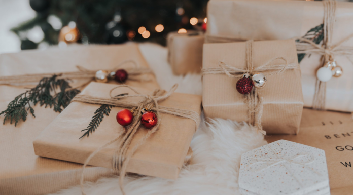Small business gifts: presents wrapped in brown paper with string and small bells lay under a tree