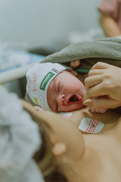 childbirth recovery: a newborn baby lays on its mother's chest.
