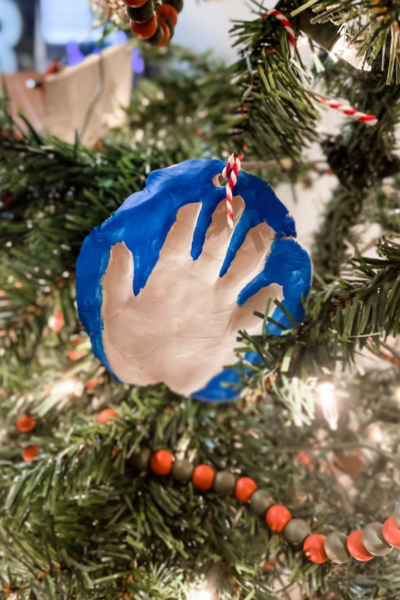 holiday crafts: A handprint ornament with a blue painted background around it, hung on a Christmas tree