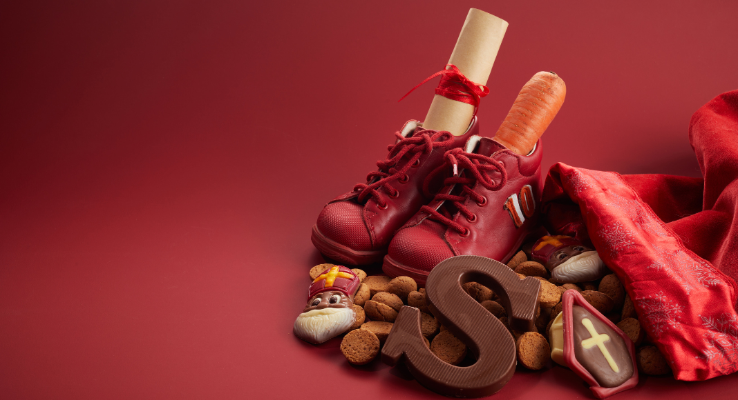 holiday traditions from around the world: red shoes with a carrot and rolled paper inside, surrounded by cookies, a chocolate S, and red background