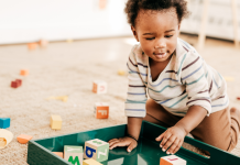 A small child playing with blocks and toddler toys.