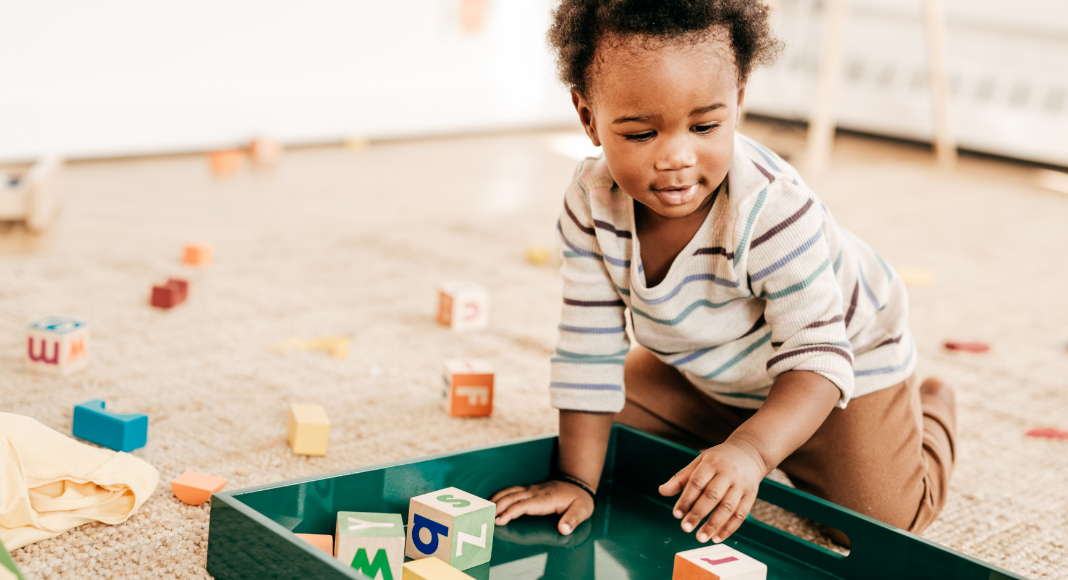 A small child playing with blocks and toddler toys.