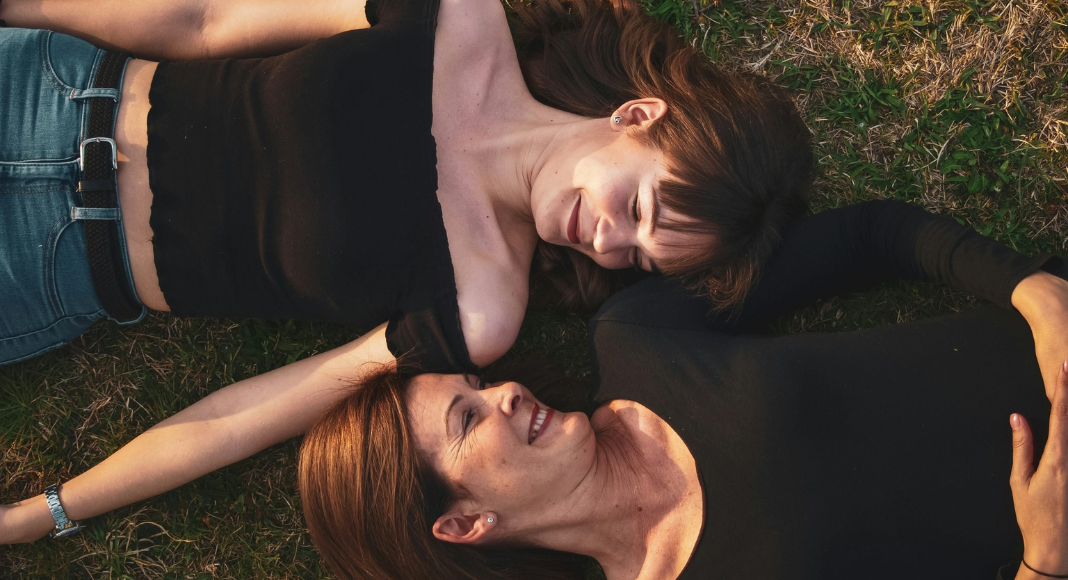 Lorelai Gilmore: a mother and daughter lay on the grass smiling at each other.