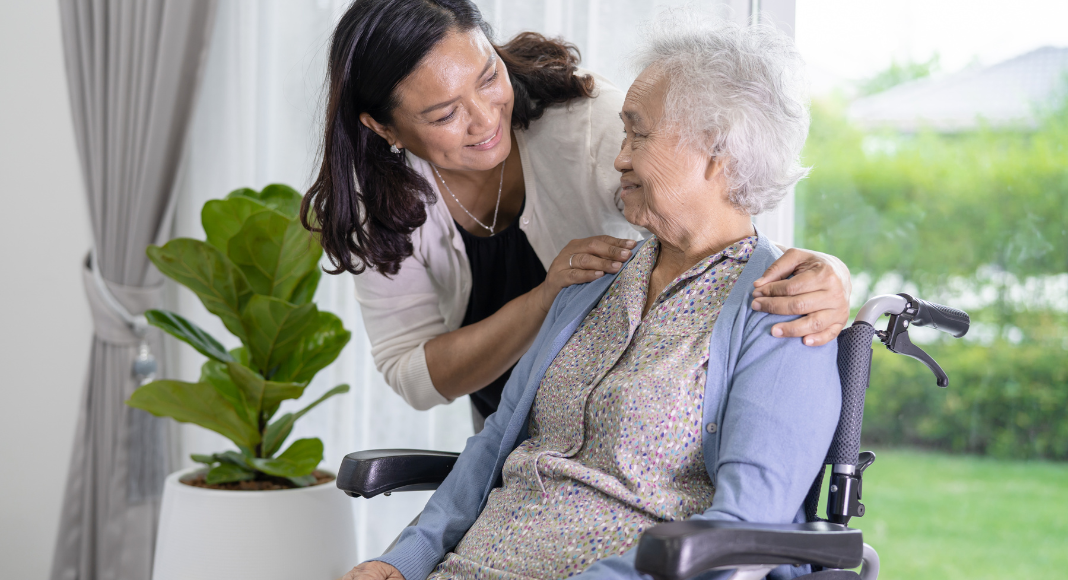 Elderly care: A nurse woman checks on an elderly woman in a wheelchair.