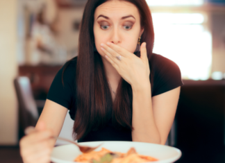 Perimenopausing: a woman eating a meal with a surprised and disturbed expression.