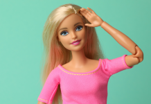 National Barbie Day: a Barbie doll in pink salutes with a friendly smile.