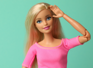 National Barbie Day: a Barbie doll in pink salutes with a friendly smile.