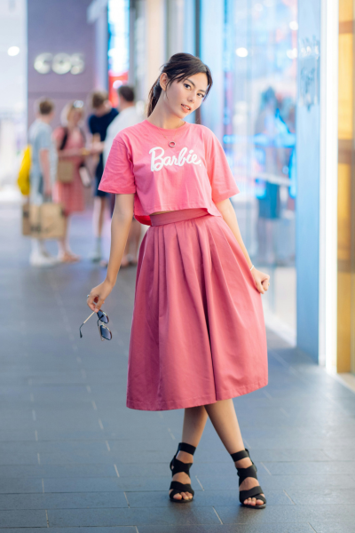A woman dressed up in pink clothes that say "Barbie"