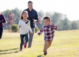 Spend more time outside: a family runs across a field together.