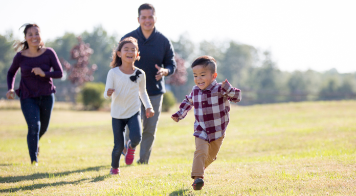 Spend more time outside: a family runs across a field together.
