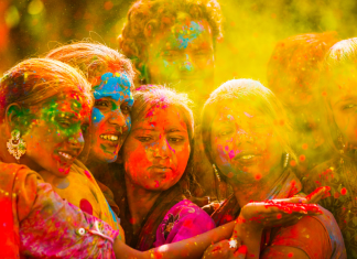 Girls gathered together for Holi, covered in colorful powders.