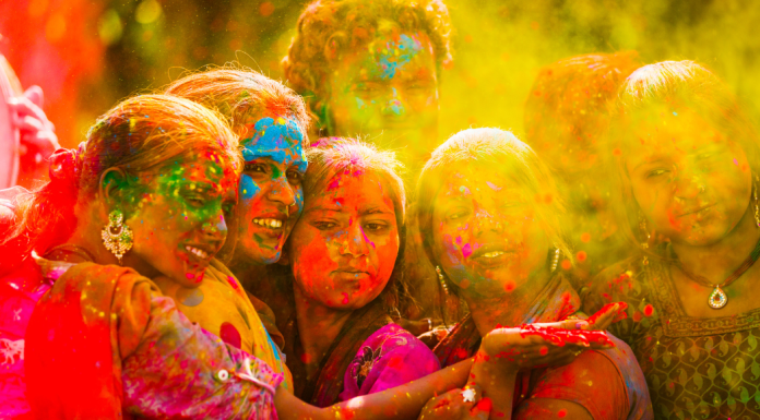 Girls gathered together for Holi, covered in colorful powders.