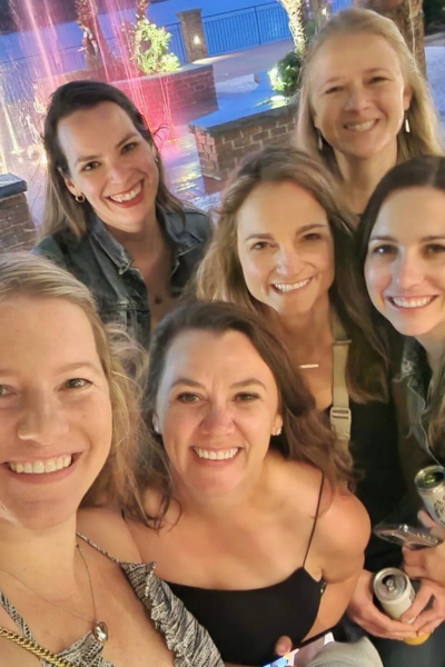 long-distance friendships: a group of 6 women huddle to take a picture together.