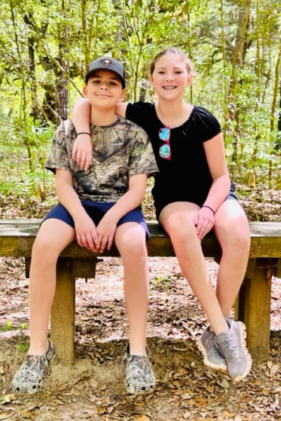 Two elementary-aged siblings sit on a bench at Caw Caw Interpretive Center.
