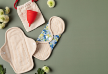 Period products: reusable pads, menstrual cup, sprawled out with flowers.