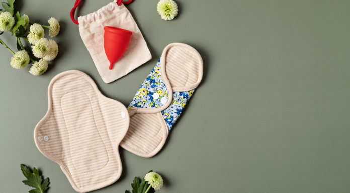 Period products: reusable pads, menstrual cup, sprawled out with flowers.