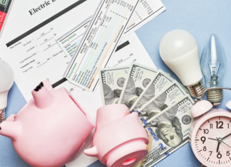 reduce monthly spending: a piggy bank broken open among a pile of cash, bills, light bulbs, clock, and calculator.