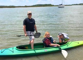 Things to do in Charleston with teens: a dad and his two teenagers pose in a kayak on the water.