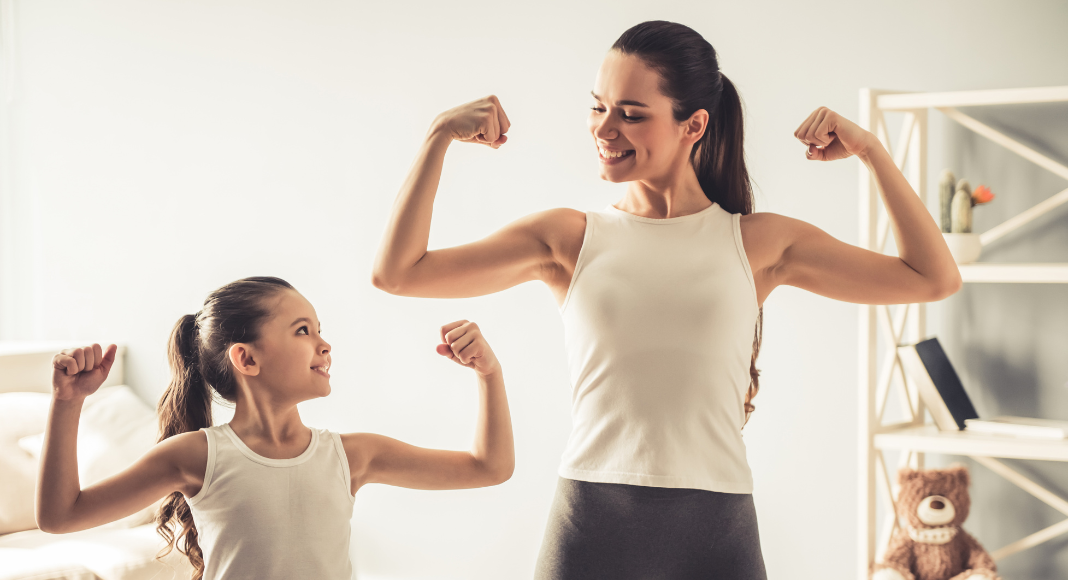 Osteoporosis: A mom and her young daughter flex their biceps and smile together.
