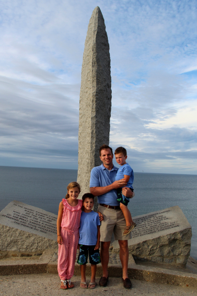 A family stands before a war monument.